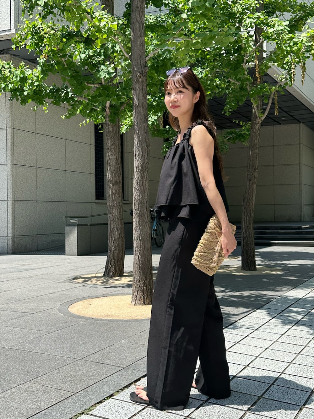 ブラック系のキャミソール、ブラック系のパンツを着用したレディースの夏コーディネートの2枚目の写真