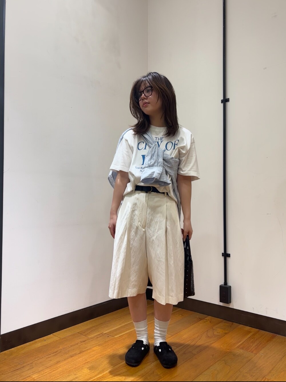 ブルー系のシャツ/ブラウス、ブルー系のTシャツ/カットソー、ブラック系のサンダルを着用したレディースの春コーディネートの4枚目の写真