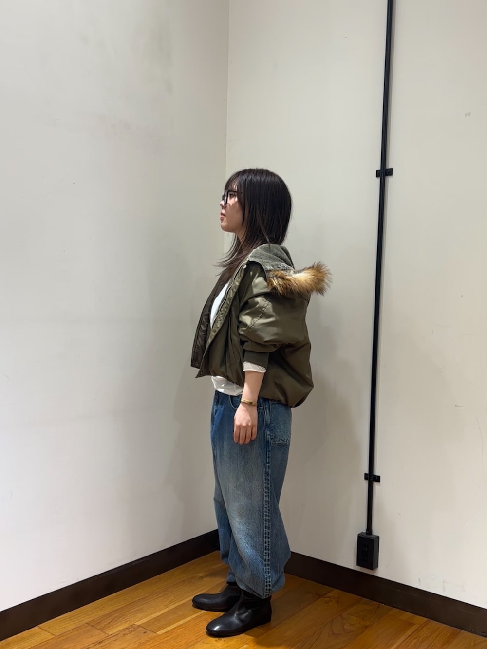 ホワイト系のTシャツ/カットソー、ブラウン系のダウンジャケット/コート、ブルー系のデニムパンツを着用したレディースの秋コーディネートの4枚目の写真