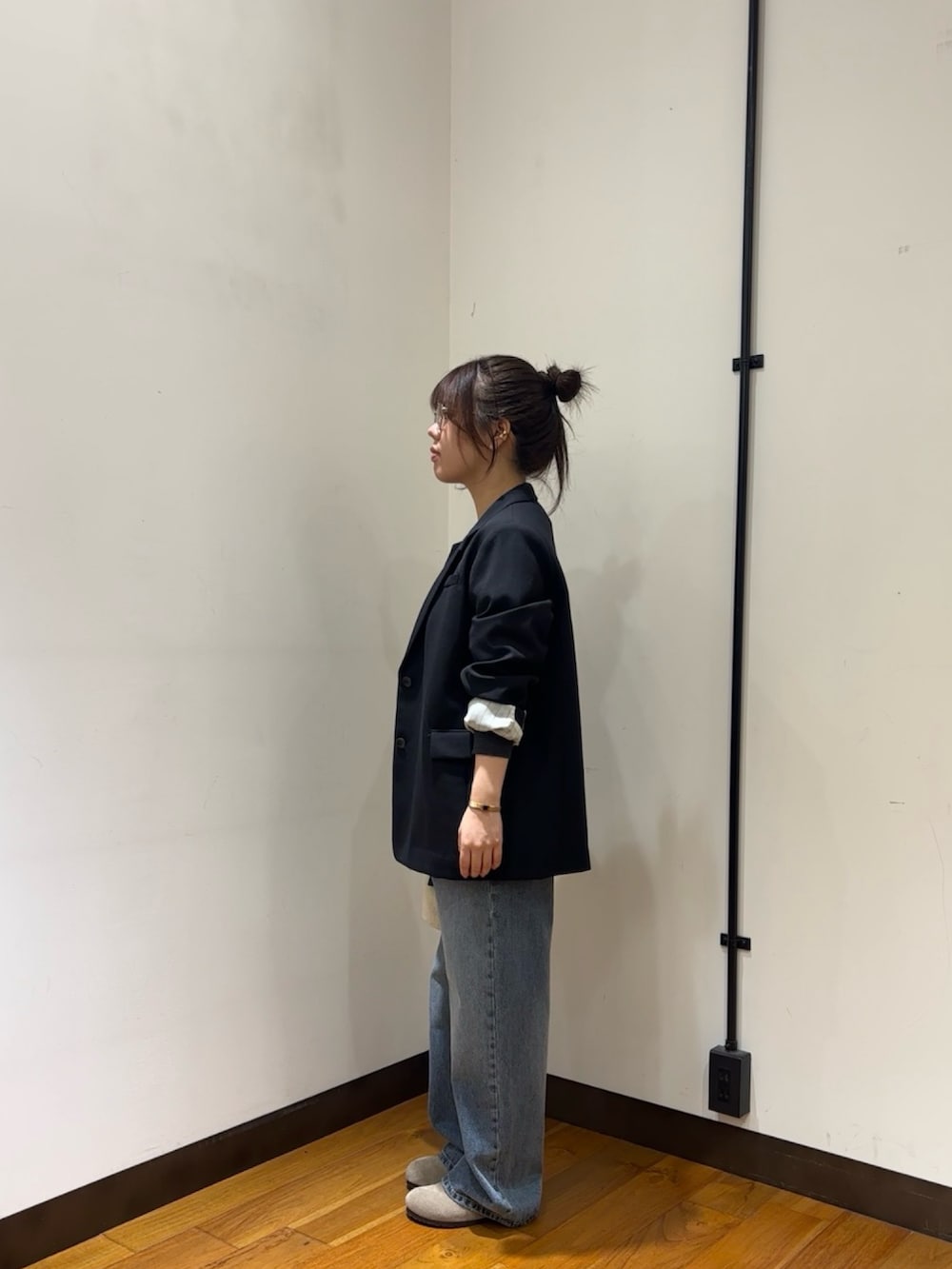 グレー系のカーディガン/ボレロ、ブラック系のその他アウター、ブルー系のデニムパンツを着用したレディースの秋コーディネートの4枚目の写真