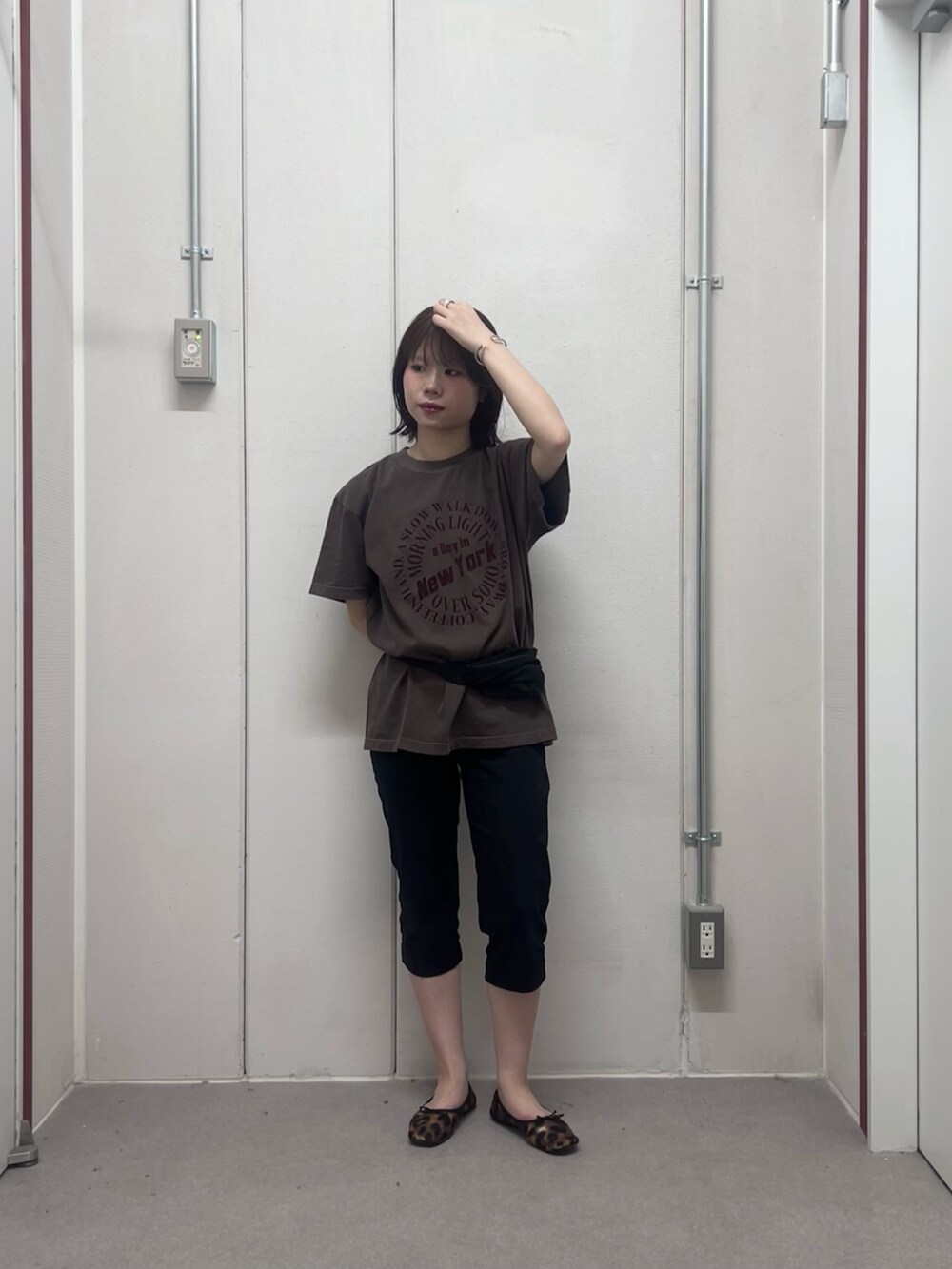 ブラウン系のTシャツ/カットソー、ブラック系のボディバッグ/ウエストポーチを着用したレディースの夏コーディネートの2枚目の写真
