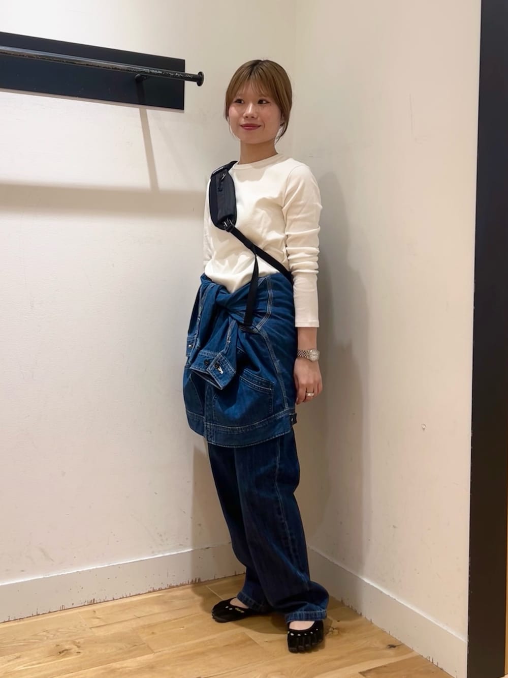 ブルー系のデニムジャケット、ブラック系のショルダーバッグ、ホワイト系のTシャツ/カットソーを着用したレディースの秋コーディネートの2枚目の写真