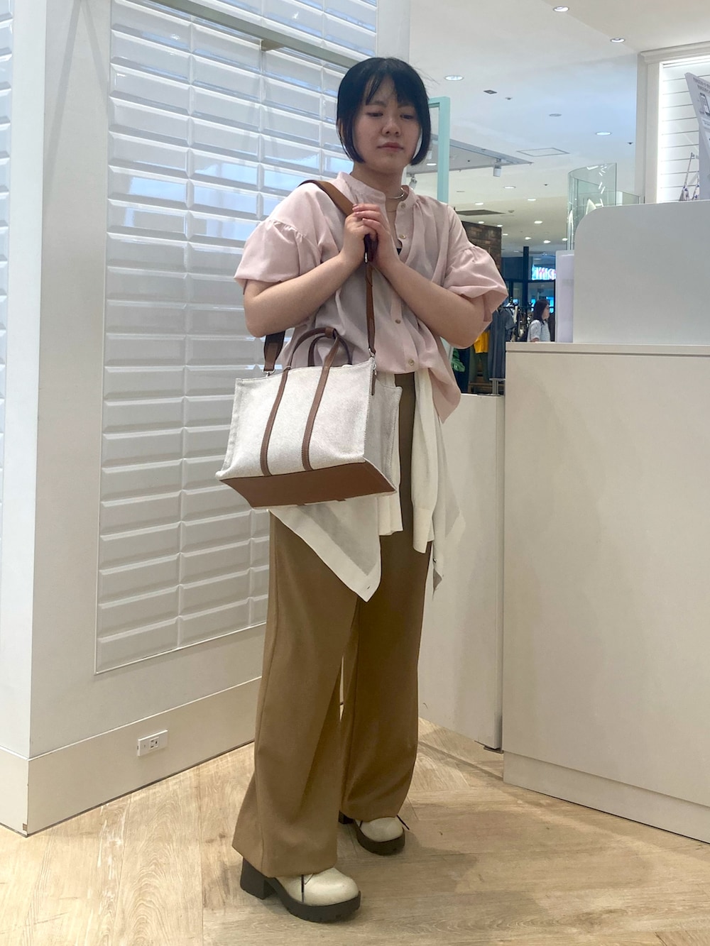 イエロー系のトートバッグ、ホワイト系のカーディガン/ボレロ、ピンク系のシャツ/ブラウスを着用したレディースの春コーディネートの2枚目の写真