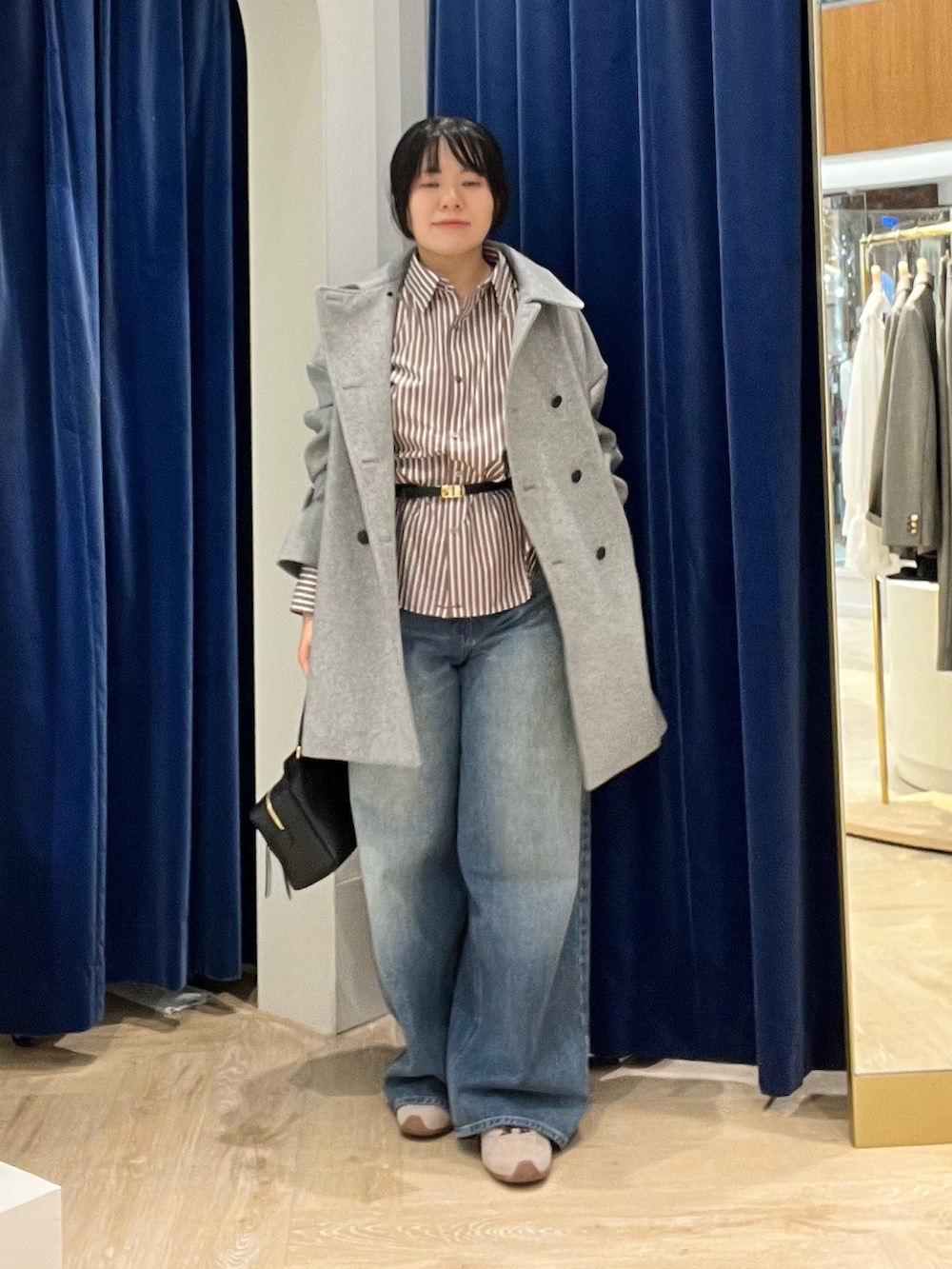 ベージュ系のシャツ/ブラウス、グレー系のピーコート、ブラック系のショルダーバッグを着用したレディースの秋コーディネートの2枚目の写真