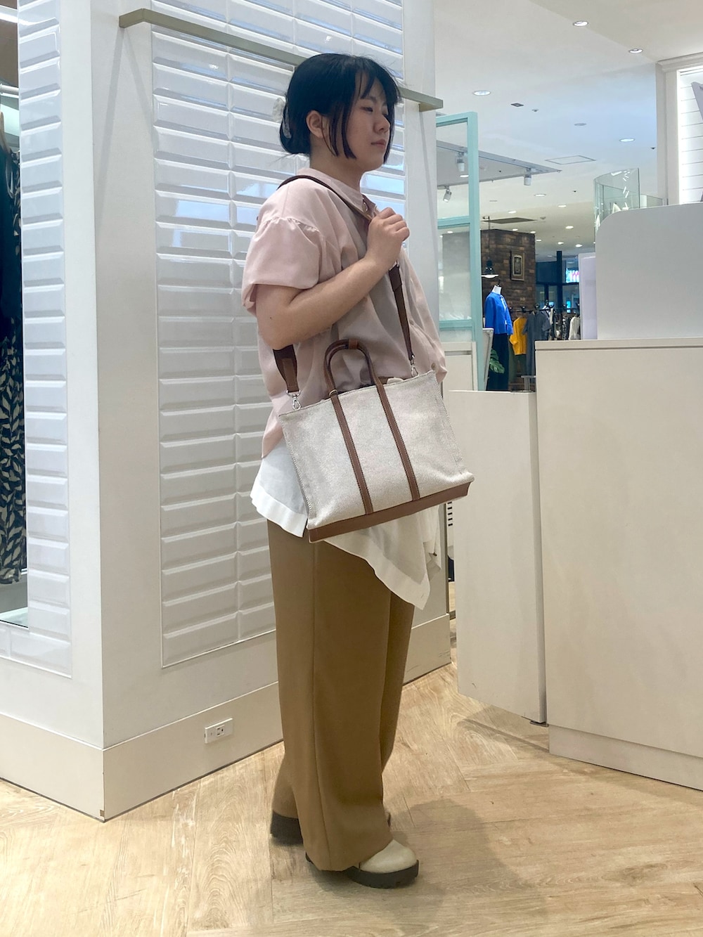 イエロー系のトートバッグ、ホワイト系のカーディガン/ボレロ、ピンク系のシャツ/ブラウスを着用したレディースの春コーディネートの3枚目の写真