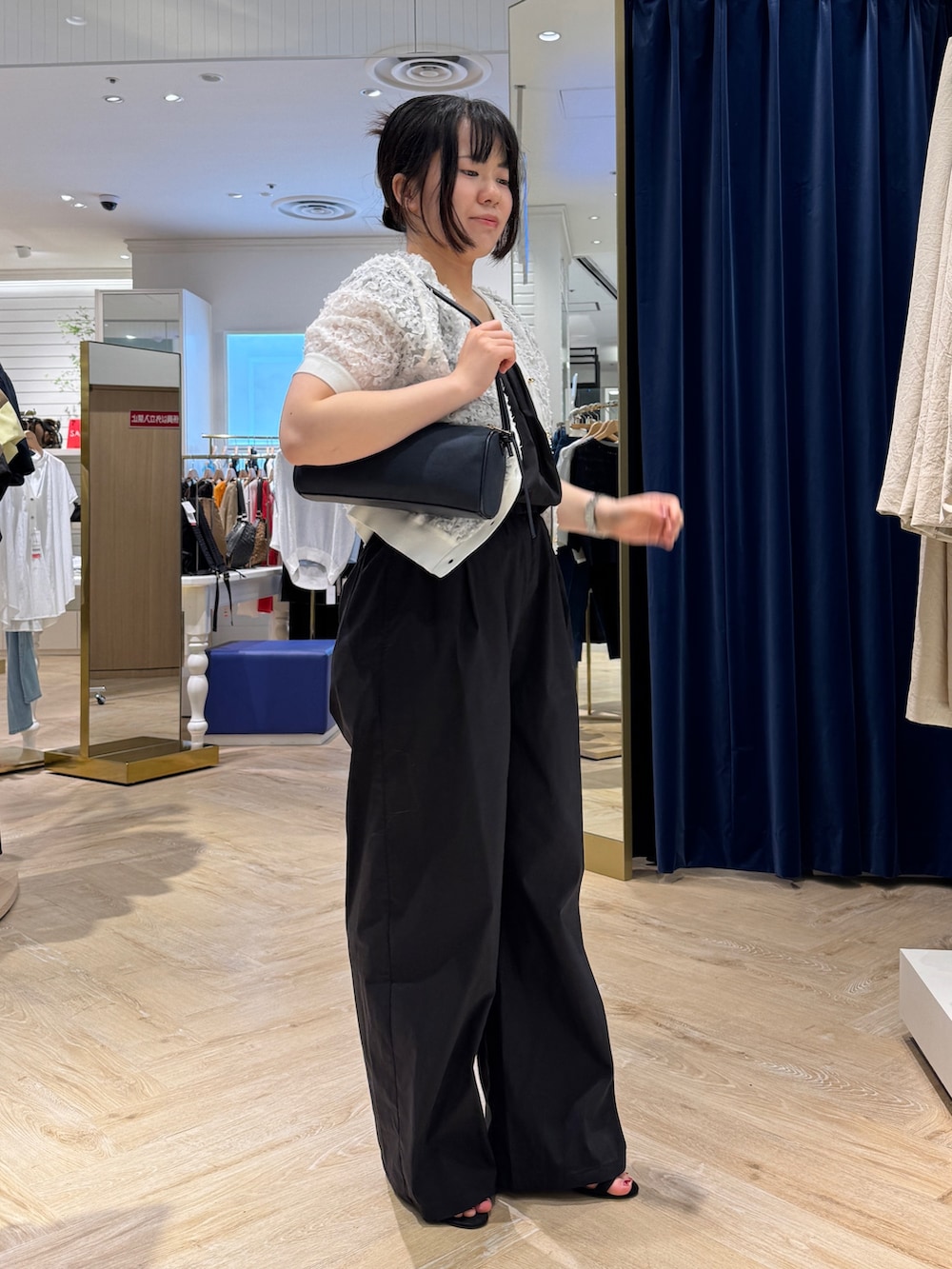 ブラック系のつなぎ/オールインワン、ホワイト系のカーディガン/ボレロ、ブルー系のショルダーバッグを着用したレディースの夏コーディネートの2枚目の写真