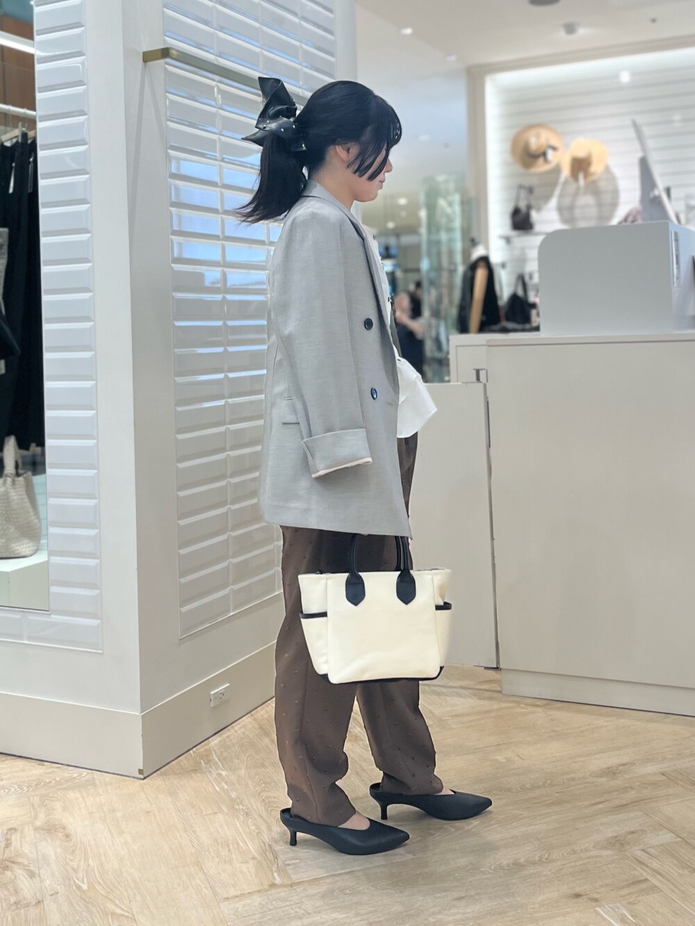 ホワイト系のシャツ/ブラウス、ベージュ系のテーラードジャケット、ブラウン系のその他パンツを着用したレディースの秋コーディネートの4枚目の写真