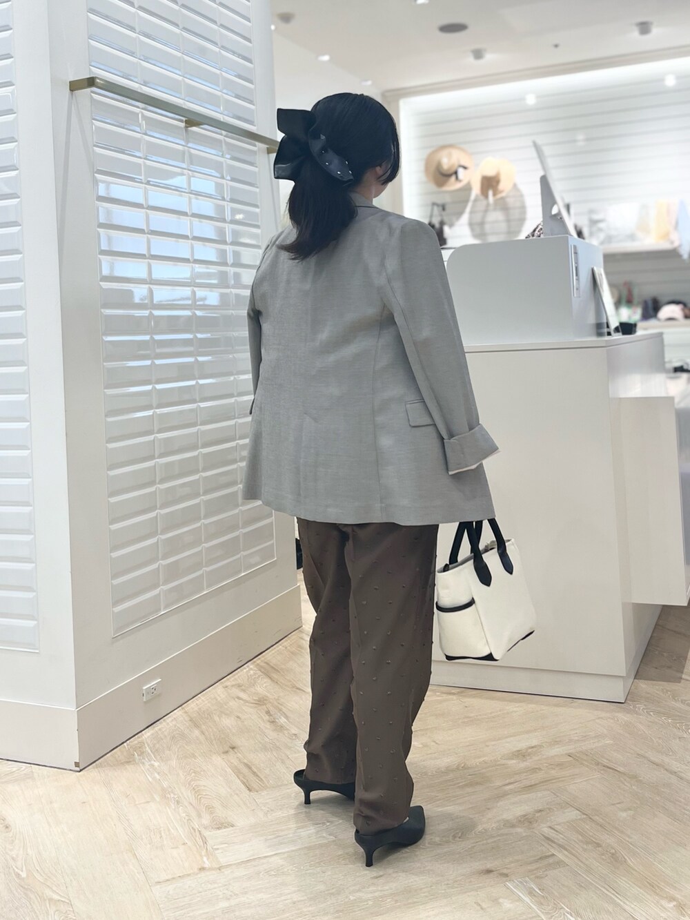 ホワイト系のシャツ/ブラウス、ベージュ系のテーラードジャケット、ブラウン系のその他パンツを着用したレディースの秋コーディネートの5枚目の写真