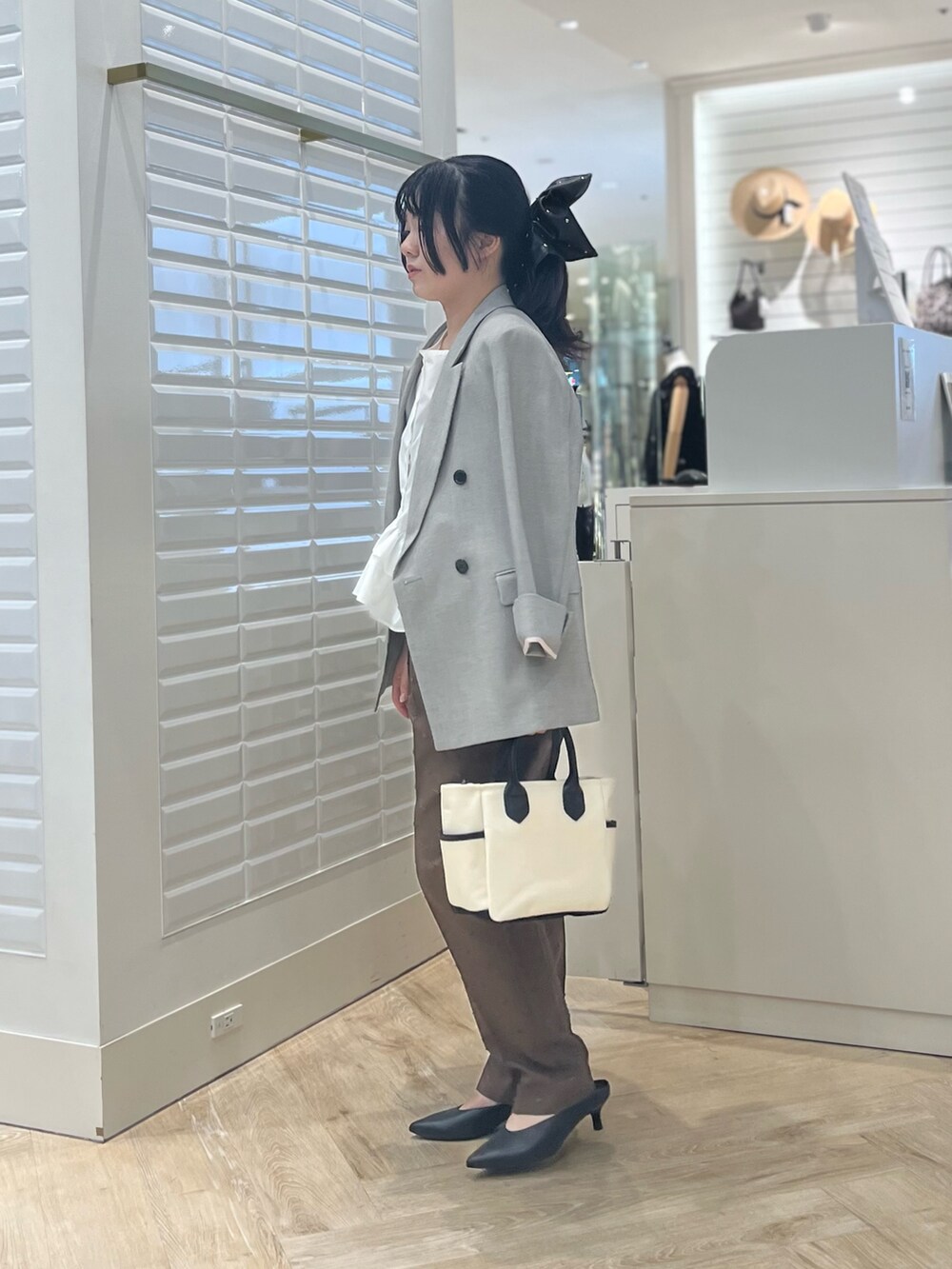 ホワイト系のシャツ/ブラウス、ベージュ系のテーラードジャケット、ブラウン系のその他パンツを着用したレディースの秋コーディネートの9枚目の写真