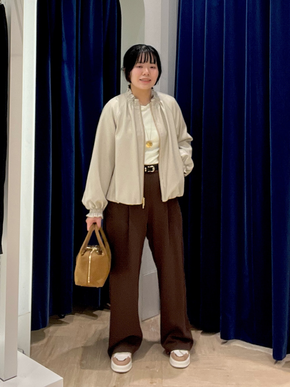 ブラウン系のその他パンツ、ブラック系のブルゾン、イエロー系のTシャツ/カットソーを着用したレディースの秋コーディネートの10枚目の写真