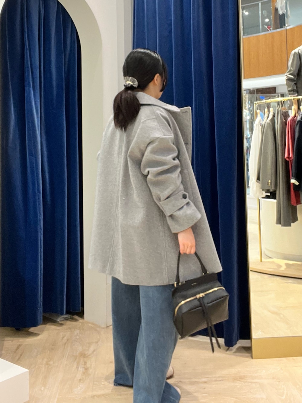 ベージュ系のシャツ/ブラウス、グレー系のピーコート、ブラック系のショルダーバッグを着用したレディースの秋コーディネートの5枚目の写真