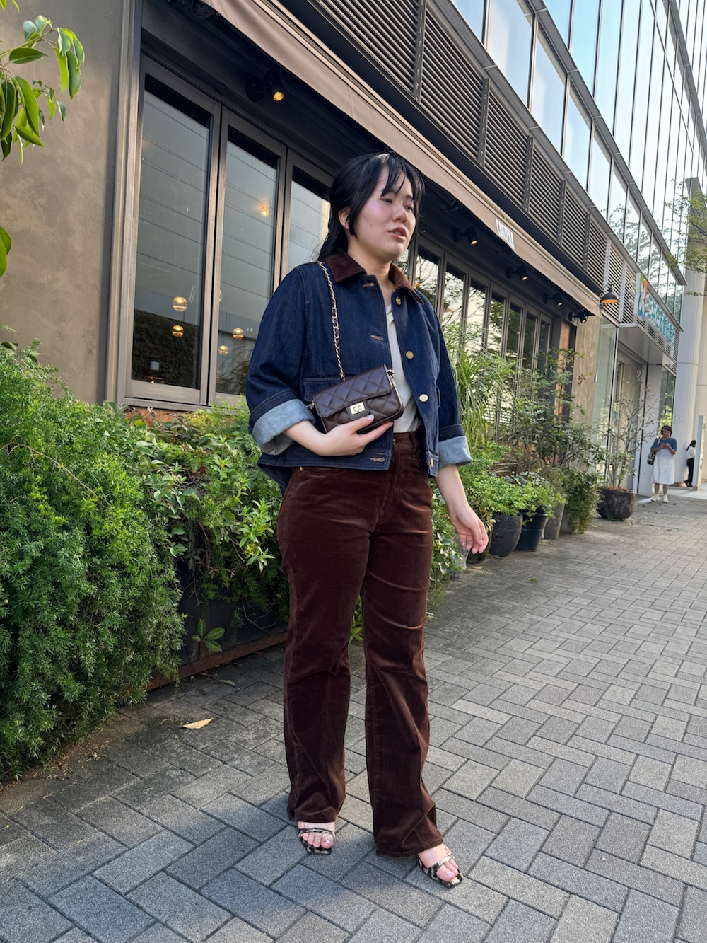 ホワイト系のTシャツ/カットソー、ブルー系のデニムジャケット、ブラウン系のショルダーバッグを着用したレディースの夏コーディネートの3枚目の写真