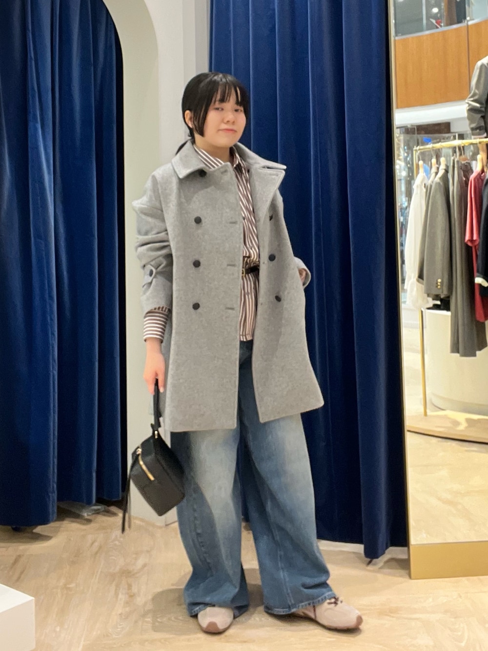ベージュ系のシャツ/ブラウス、グレー系のピーコート、ブラック系のショルダーバッグを着用したレディースの秋コーディネートの3枚目の写真