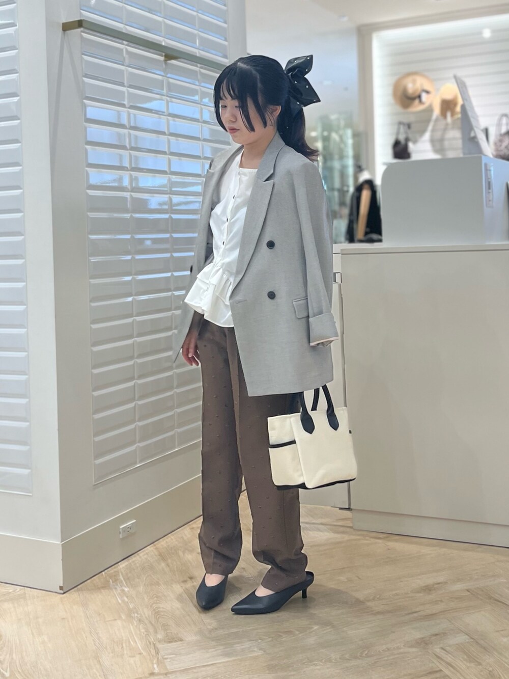 ホワイト系のシャツ/ブラウス、ベージュ系のテーラードジャケット、ブラウン系のその他パンツを着用したレディースの秋コーディネートの10枚目の写真
