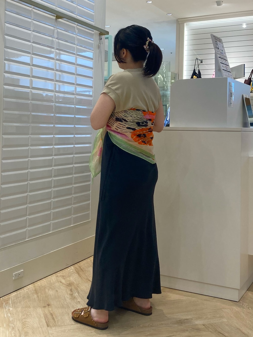ベージュ系のTシャツ/カットソー、ブラック系のスカート、イエロー系のサンダルを着用したレディースの夏コーディネートの5枚目の写真