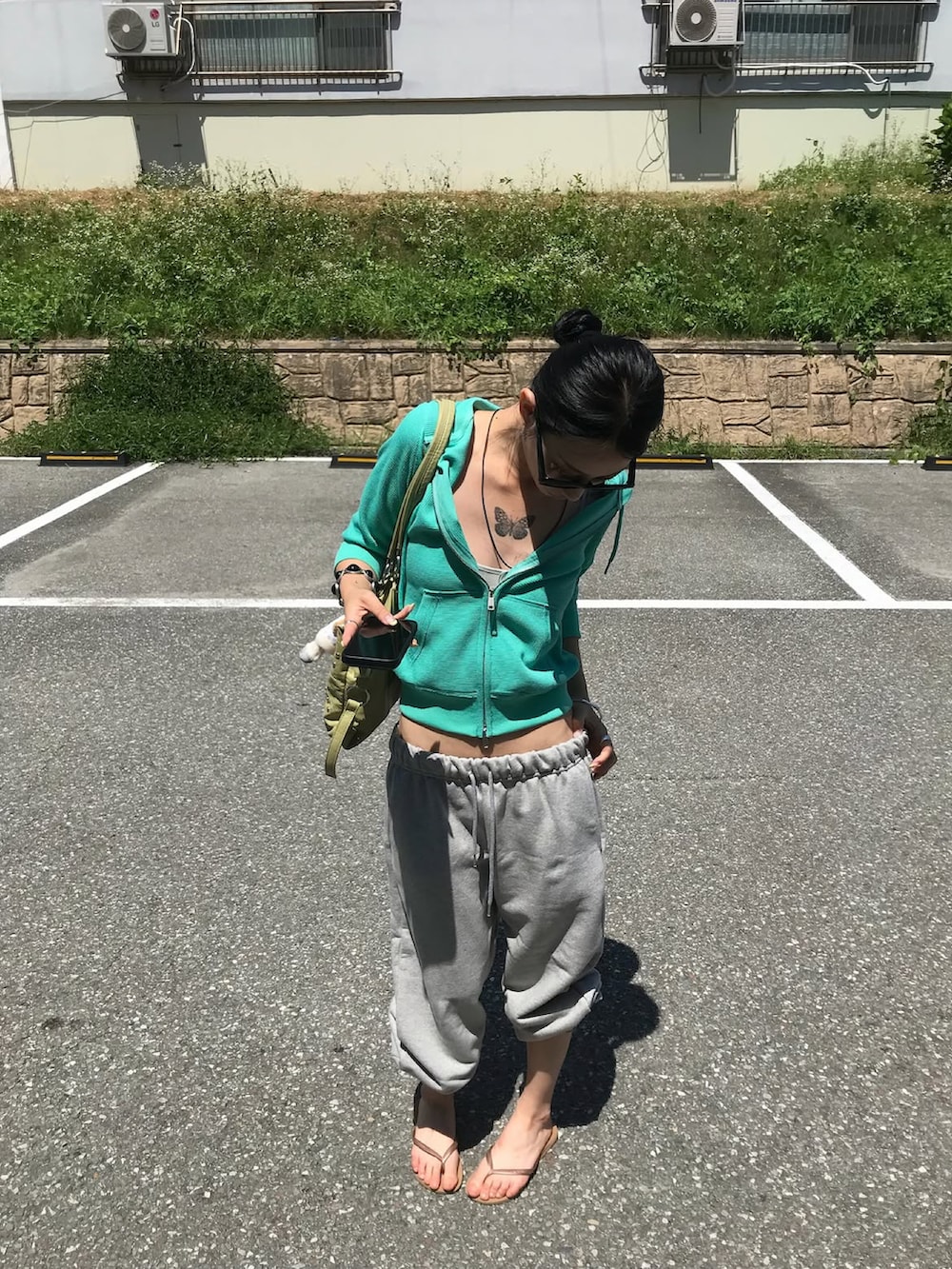 グレー系のパーカー、グレー系のスウェットパンツを着用したレディースの秋コーディネートの3枚目の写真