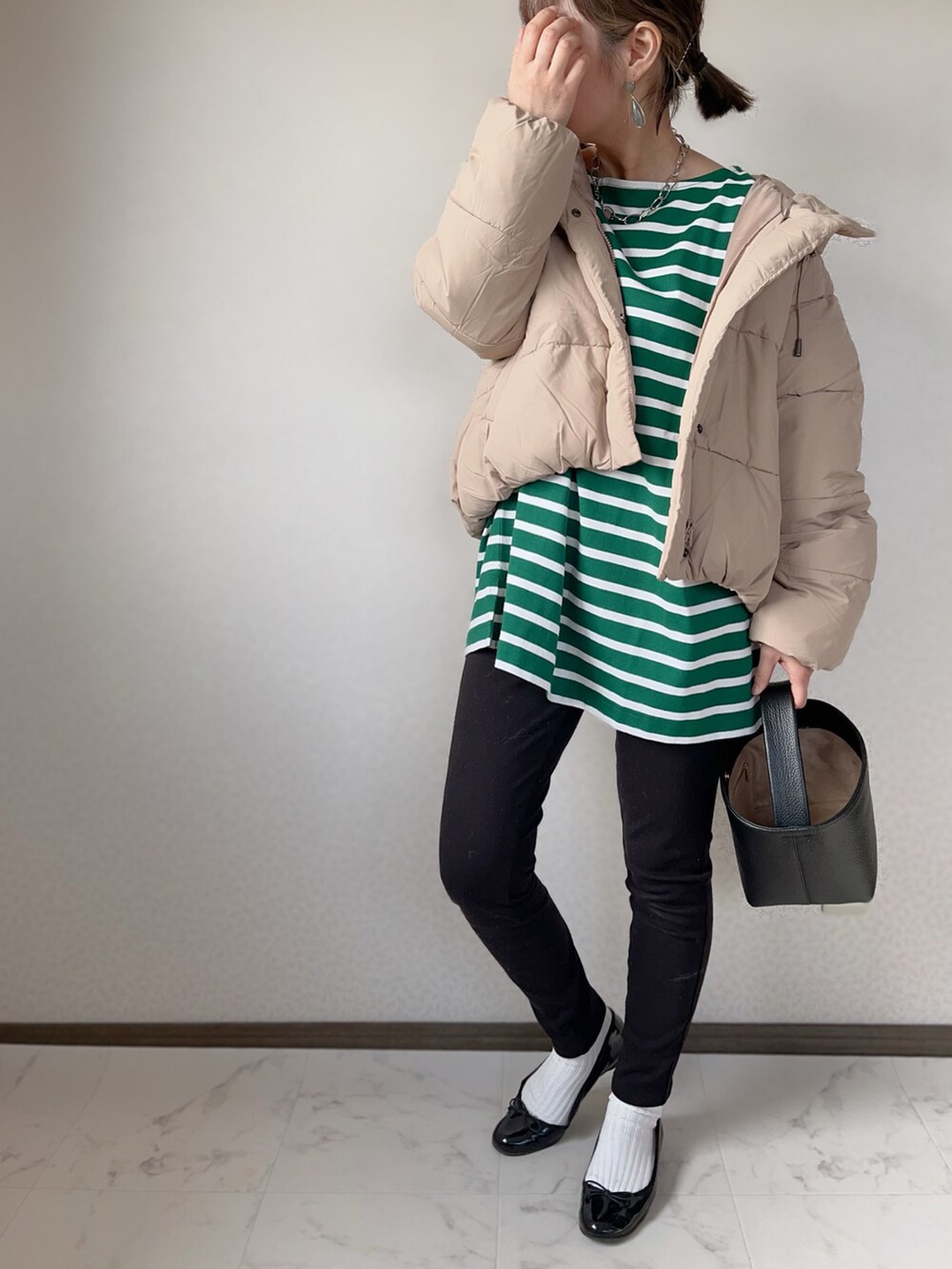 ベージュ系のダウンジャケット/コート、グリーン系のTシャツ/カットソー、シルバー系のネックレスを着用したレディースの秋コーディネートの2枚目の写真