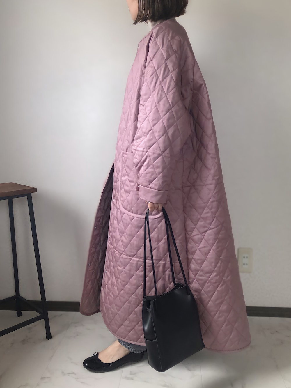 ピンク系のノーカラーコート、ベージュ系のTシャツ/カットソー、グレー系のデニムパンツを着用したレディースの秋コーディネートの2枚目の写真