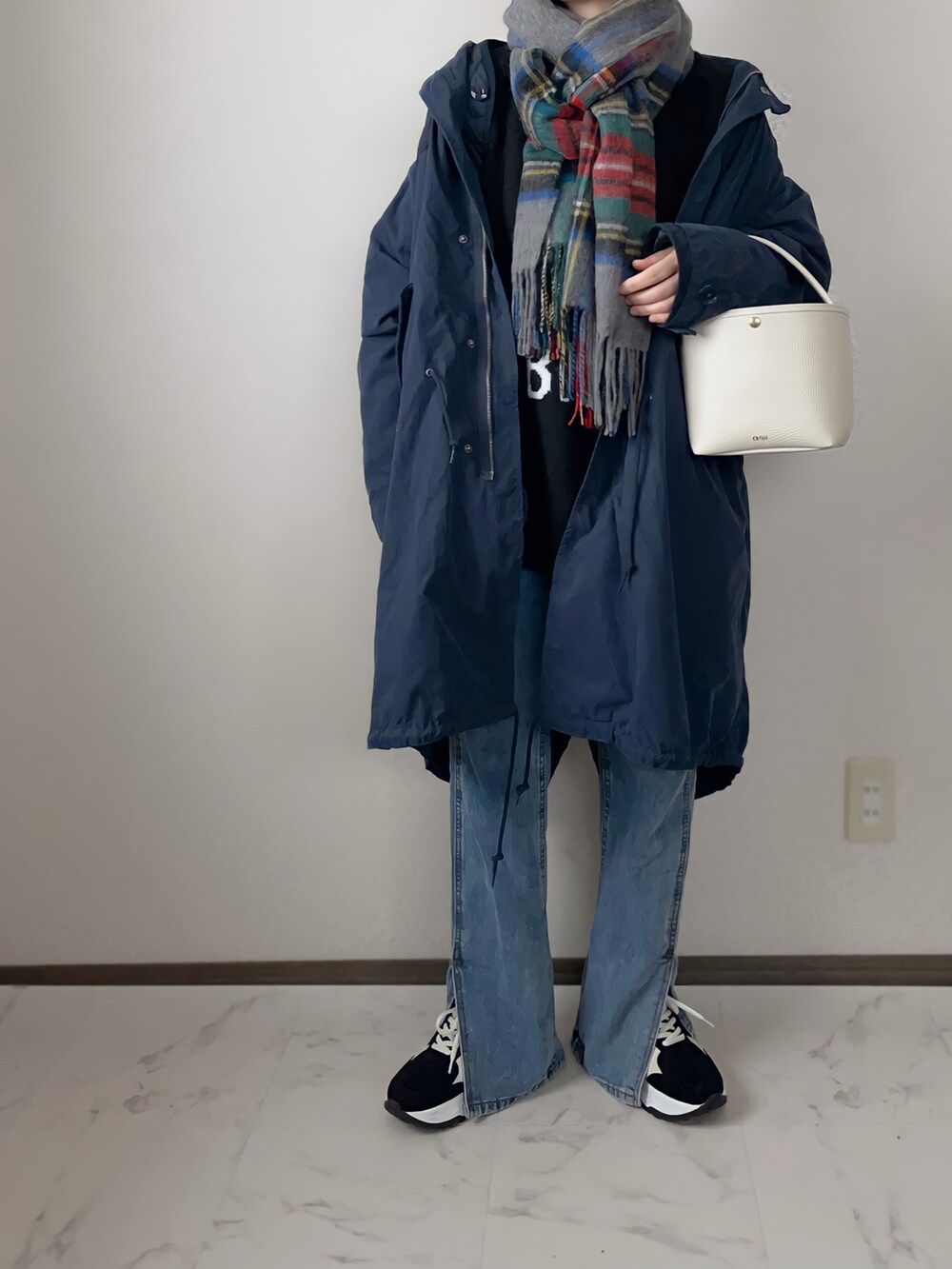 ブルー系のモッズコート、ブルー系のデニムパンツ、ブラック系のスニーカーを着用したレディースの冬コーディネートの2枚目の写真