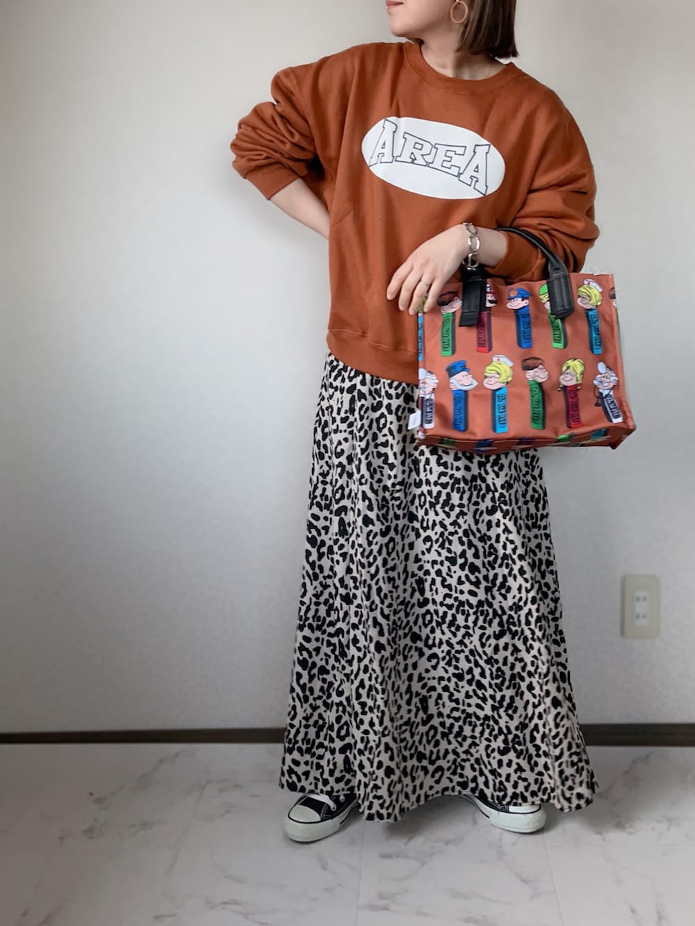 ブラウン系のトートバッグ、オレンジ系のスウェット、ベージュ系のスカートを着用したレディースの冬コーディネートの2枚目の写真