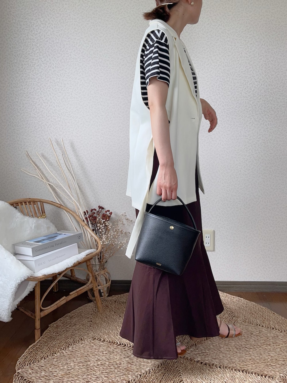 ブラウン系のスカート、ホワイト系のベストを着用したレディースの夏コーディネートの3枚目の写真