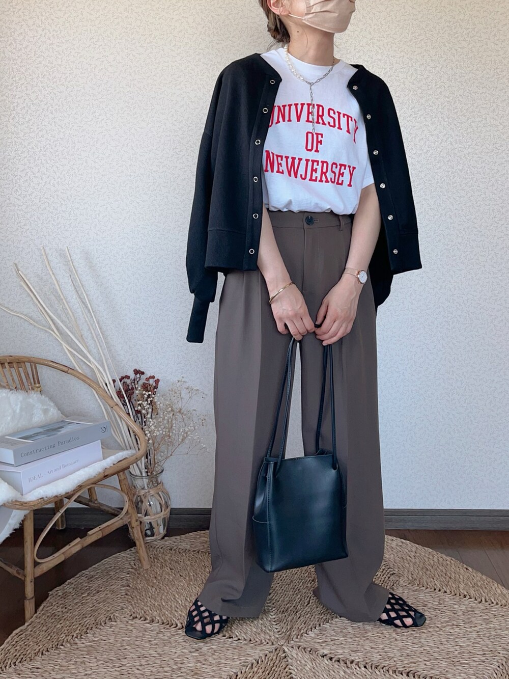 ホワイト系のTシャツ/カットソー、ブラウン系のスラックス、ブラック系のカーディガン/ボレロを着用したレディースの春コーディネートの2枚目の写真