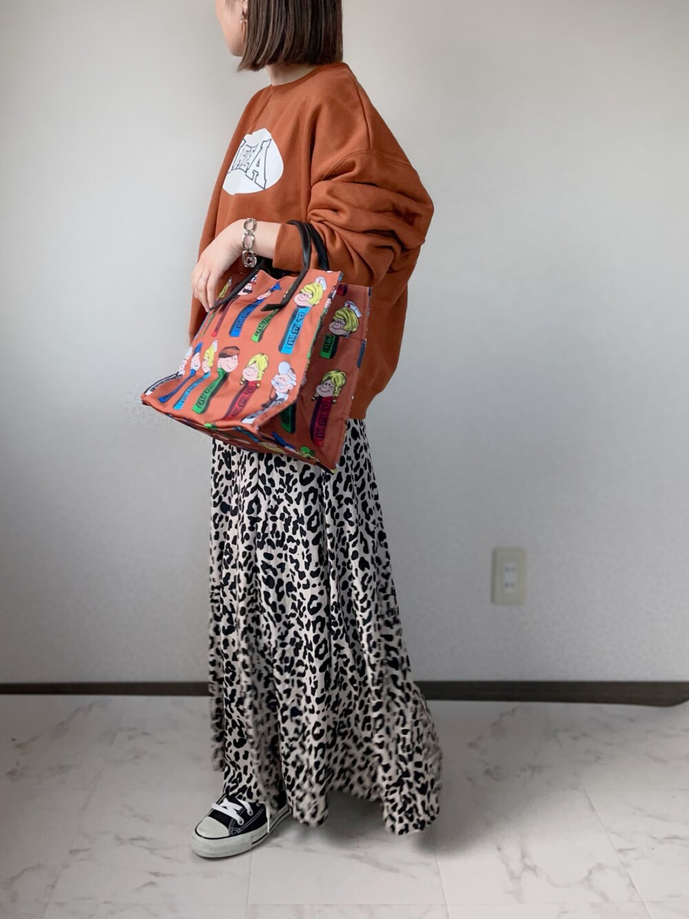 ブラウン系のトートバッグ、オレンジ系のスウェット、ベージュ系のスカートを着用したレディースの冬コーディネートの3枚目の写真