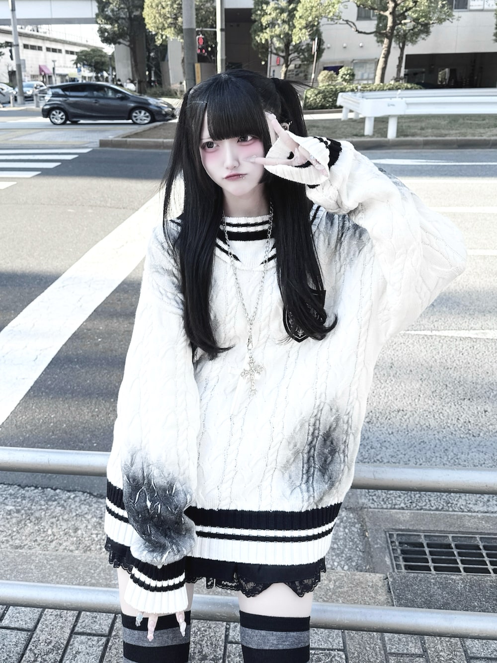 ホワイト系のニット/セーター、ブラック系のスカート、ブラック系のスニーカーを着用したレディースの冬コーディネートの2枚目の写真