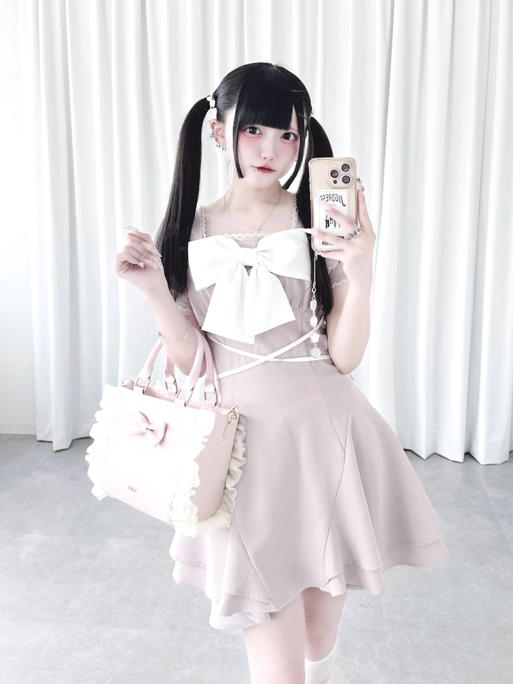 ピンク系のワンピース、ピンク系のショルダーバッグを着用したレディースの夏コーディネートの2枚目の写真