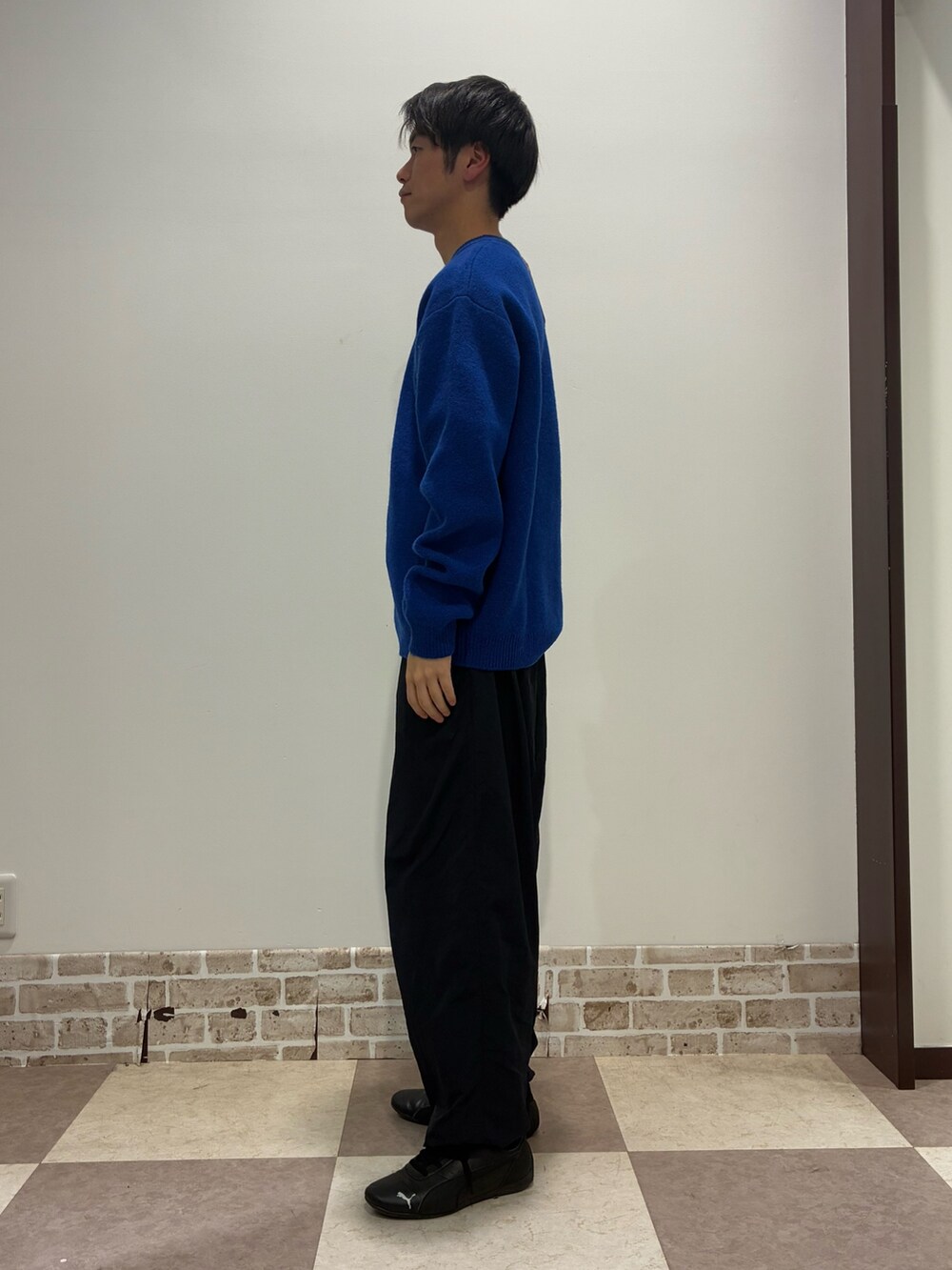 ブルー系のニット/セーターを着用したメンズの冬コーディネートの2枚目の写真