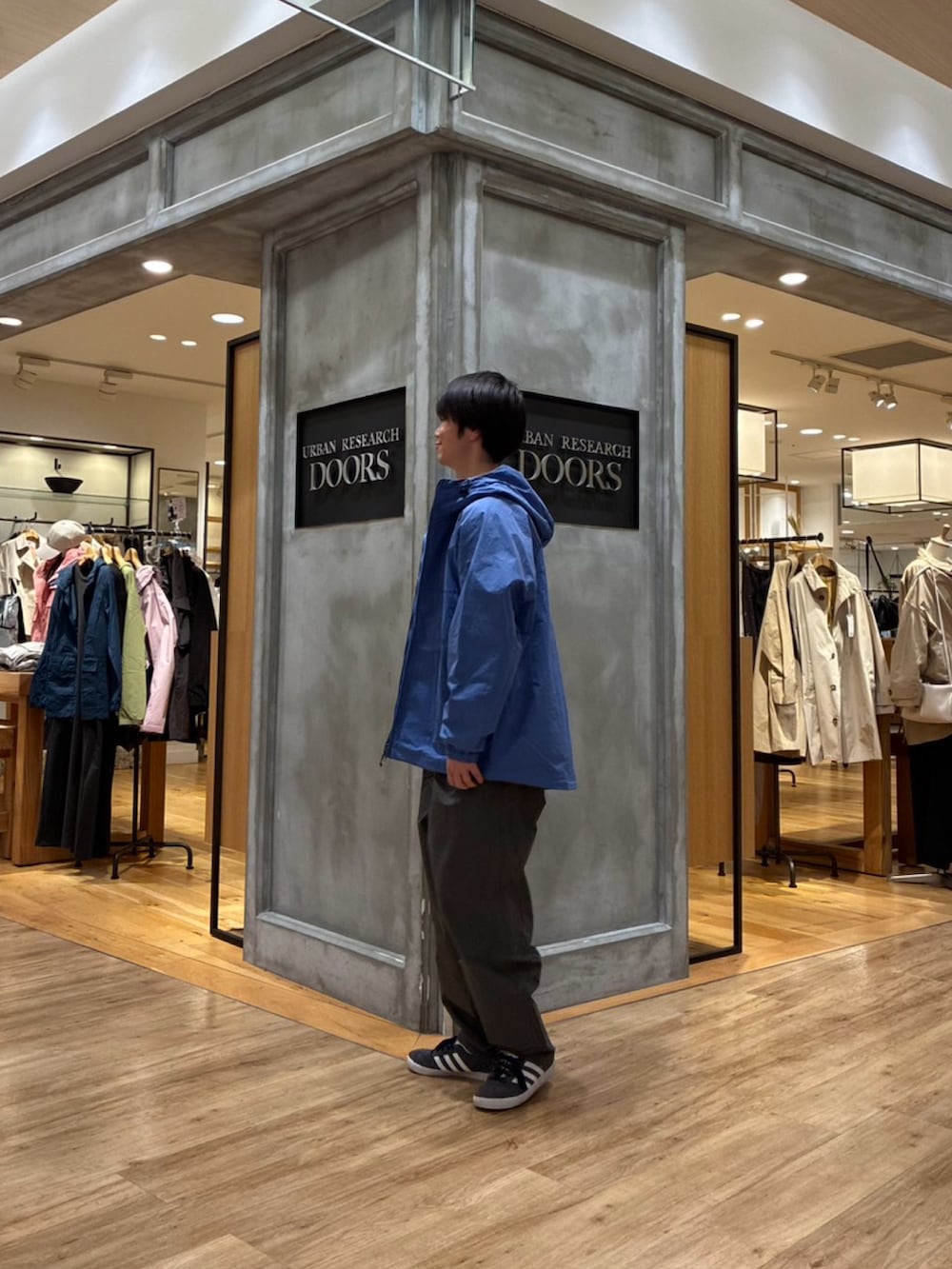 ブルー系のナイロンジャケットを着用したメンズの春コーディネートの2枚目の写真