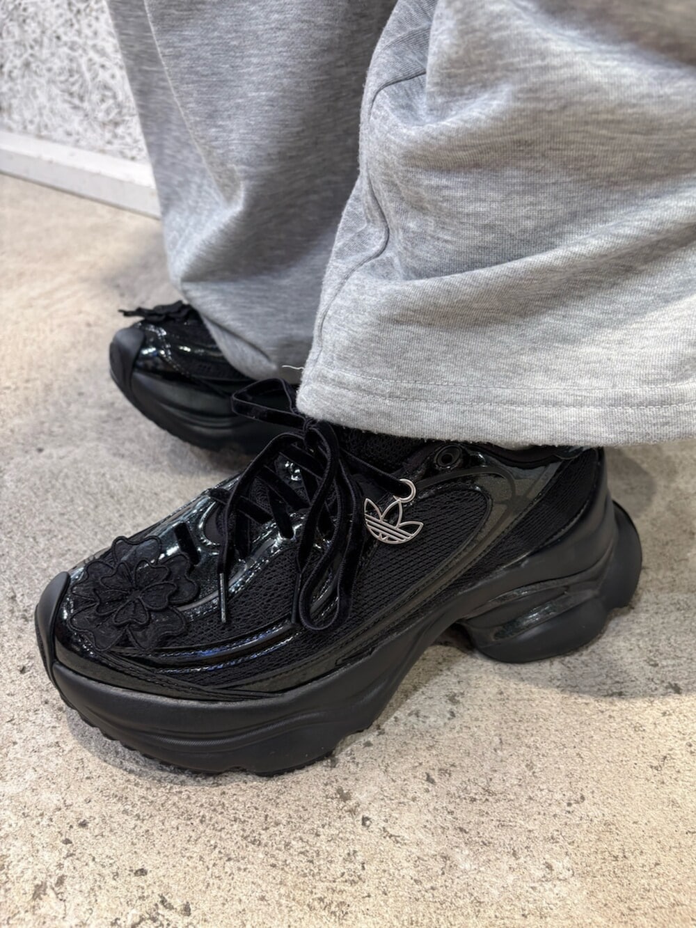 ブラック系のスニーカー、ブラウン系のトップスを着用したレディースの春コーディネートの4枚目の写真