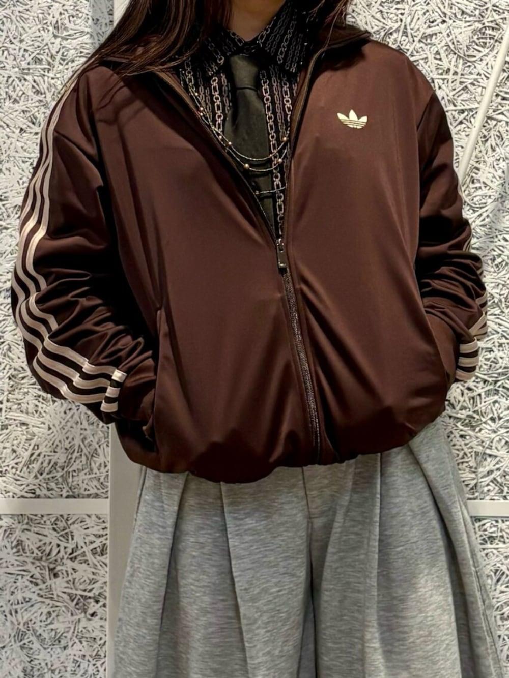 ブラック系のスニーカー、ブラウン系のトップスを着用したレディースの春コーディネートの2枚目の写真