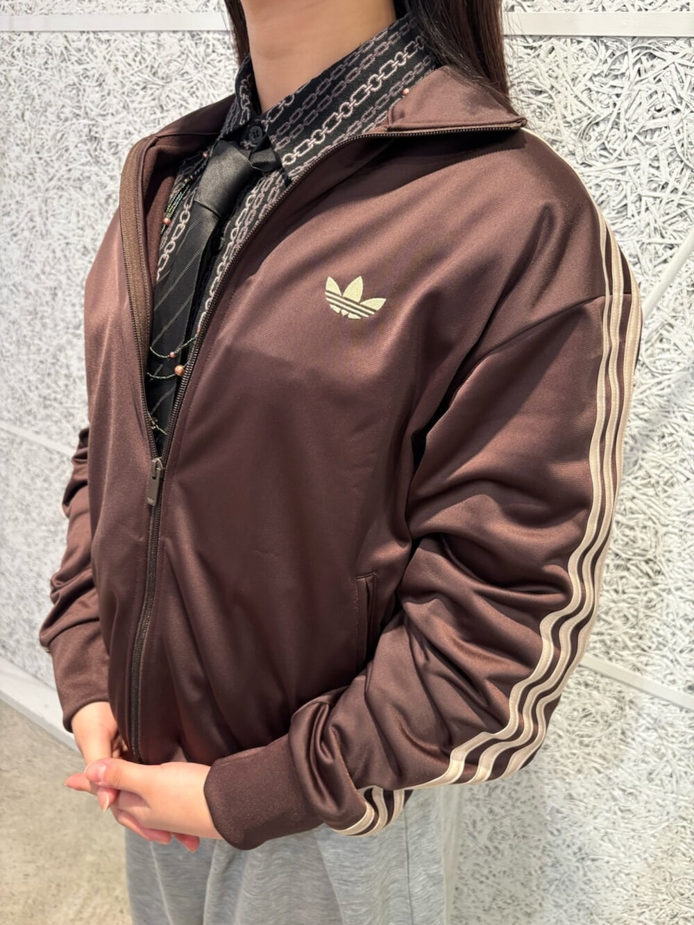 ブラック系のスニーカー、ブラウン系のトップスを着用したレディースの春コーディネートの3枚目の写真