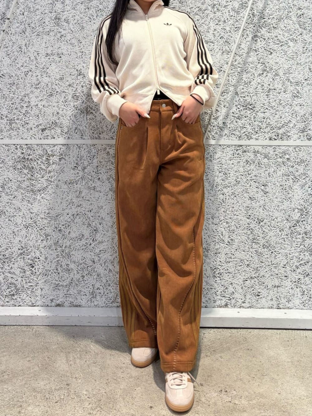 ベージュ系のスニーカー、ブラウン系のパンツ、ホワイト系のジャージを着用したレディースの冬コーディネートの2枚目の写真