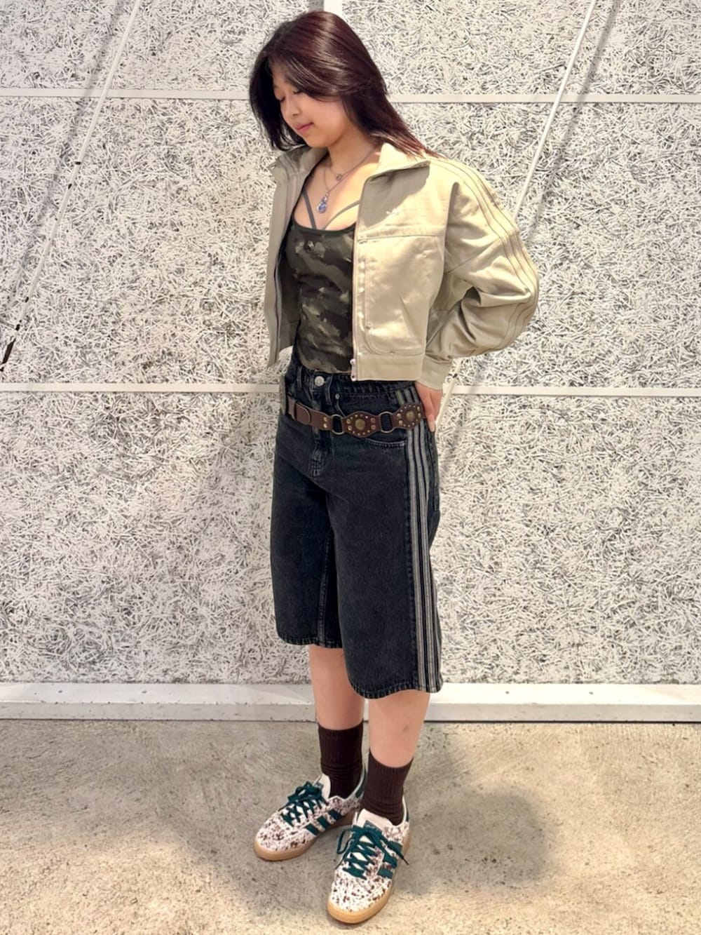 グリーン系のデニムジャケット、ブラック系のデニムパンツ、ホワイト系のスニーカーを着用したレディースの夏コーディネートの2枚目の写真