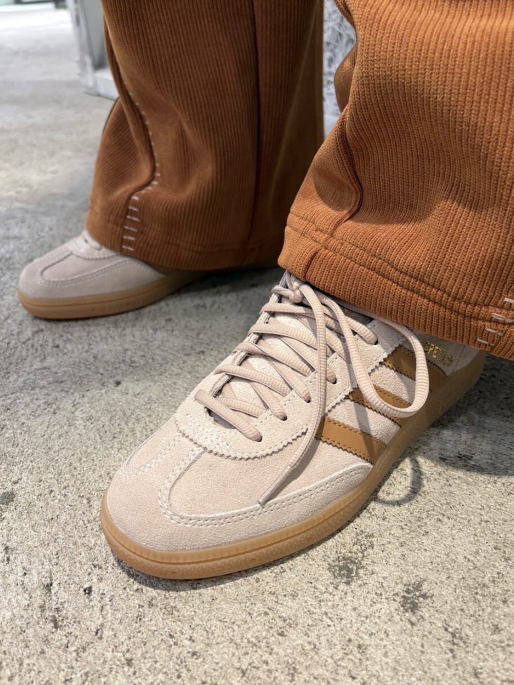 ベージュ系のスニーカー、ブラウン系のパンツ、ホワイト系のジャージを着用したレディースの冬コーディネートの4枚目の写真