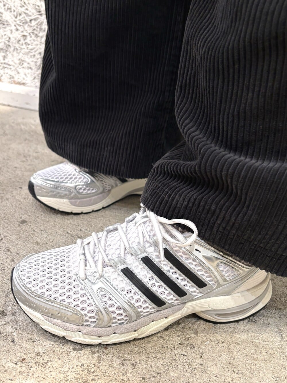 ブルー系のトップス、シルバー系のデニムパンツ、ブラック系のスウェットパンツを着用したレディースの冬コーディネートの4枚目の写真