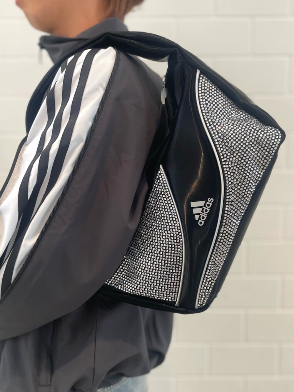 ブラック系のシューズ、ブラック系のジャージ、ブルー系のデニムパンツを着用したメンズの春コーディネートの4枚目の写真