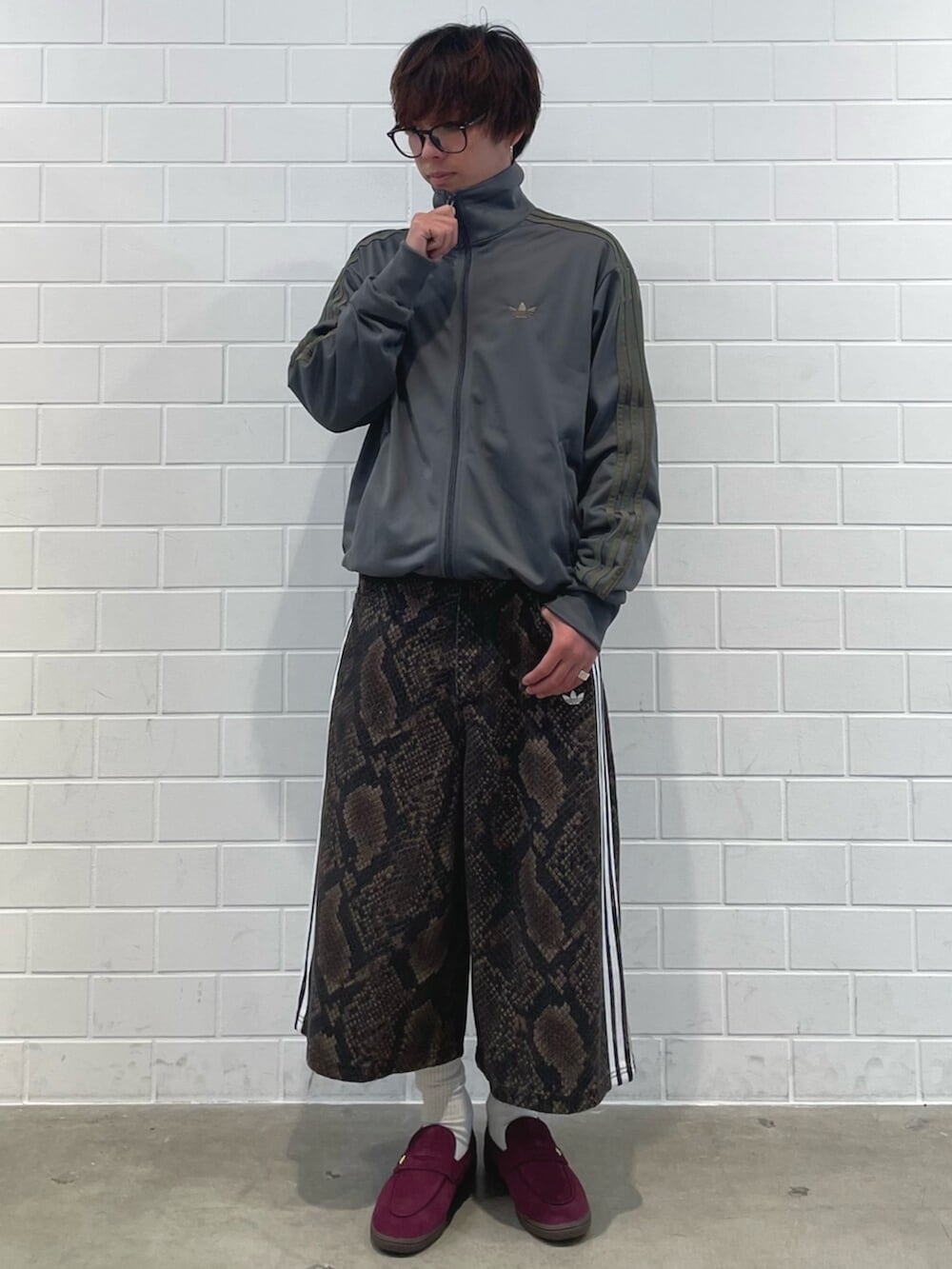 レッド系のスニーカー、グレー系のジャージ、ブラウン系のデニムパンツを着用したメンズの夏コーディネートの3枚目の写真