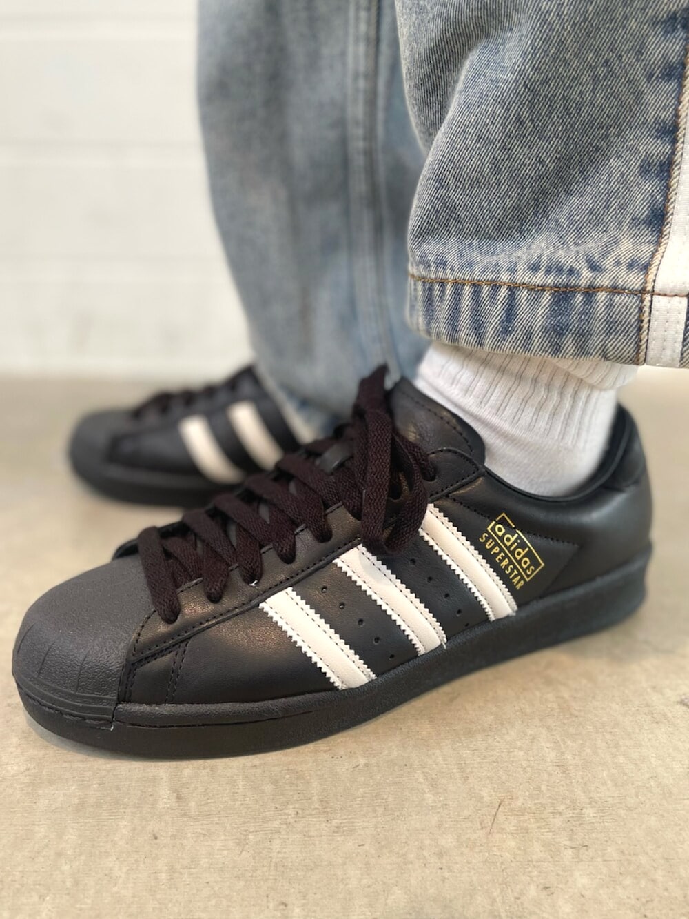 ブラック系のシューズ、ブラック系のジャージ、ブルー系のデニムパンツを着用したメンズの春コーディネートの6枚目の写真