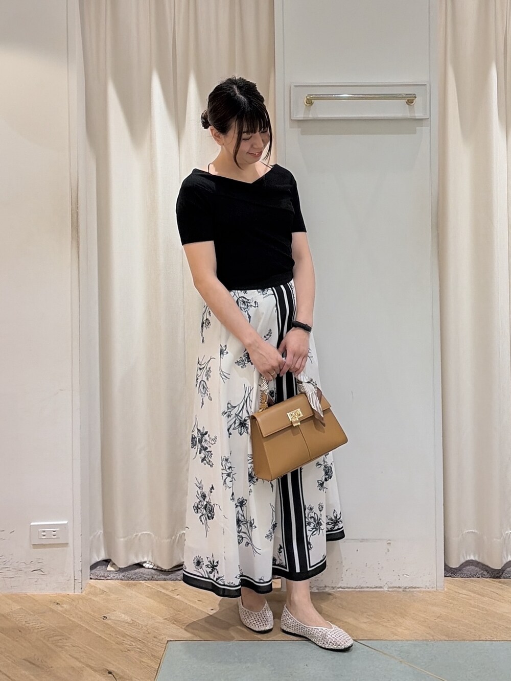 ホワイト系のスカート、ブラック系のTシャツ/カットソー、ブラウン系のハンドバッグを着用したレディースの春コーディネートの5枚目の写真