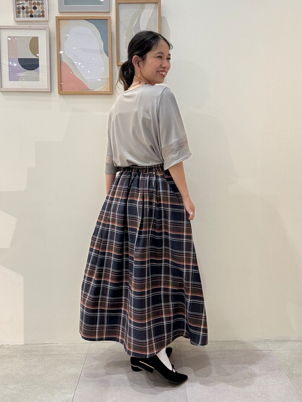 ブラック系のトートバッグ、グレー系のTシャツ/カットソー、ブラウン系のスカートを着用したレディースの春コーディネートの3枚目の写真