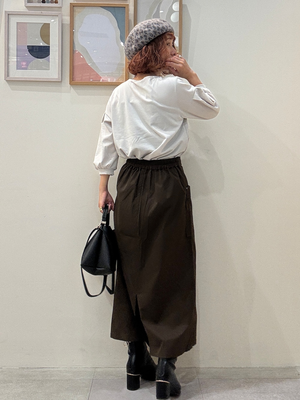 グレー系のTシャツ/カットソー、ブラウン系のスカート、ブラック系のブーツを着用したレディースの秋コーディネートの3枚目の写真