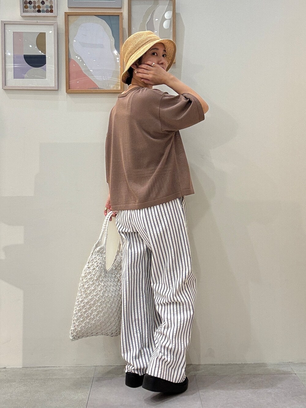 ブラウン系のニット/セーター、ベージュ系のその他パンツ、ホワイト系のトートバッグを着用したレディースの春コーディネートの3枚目の写真