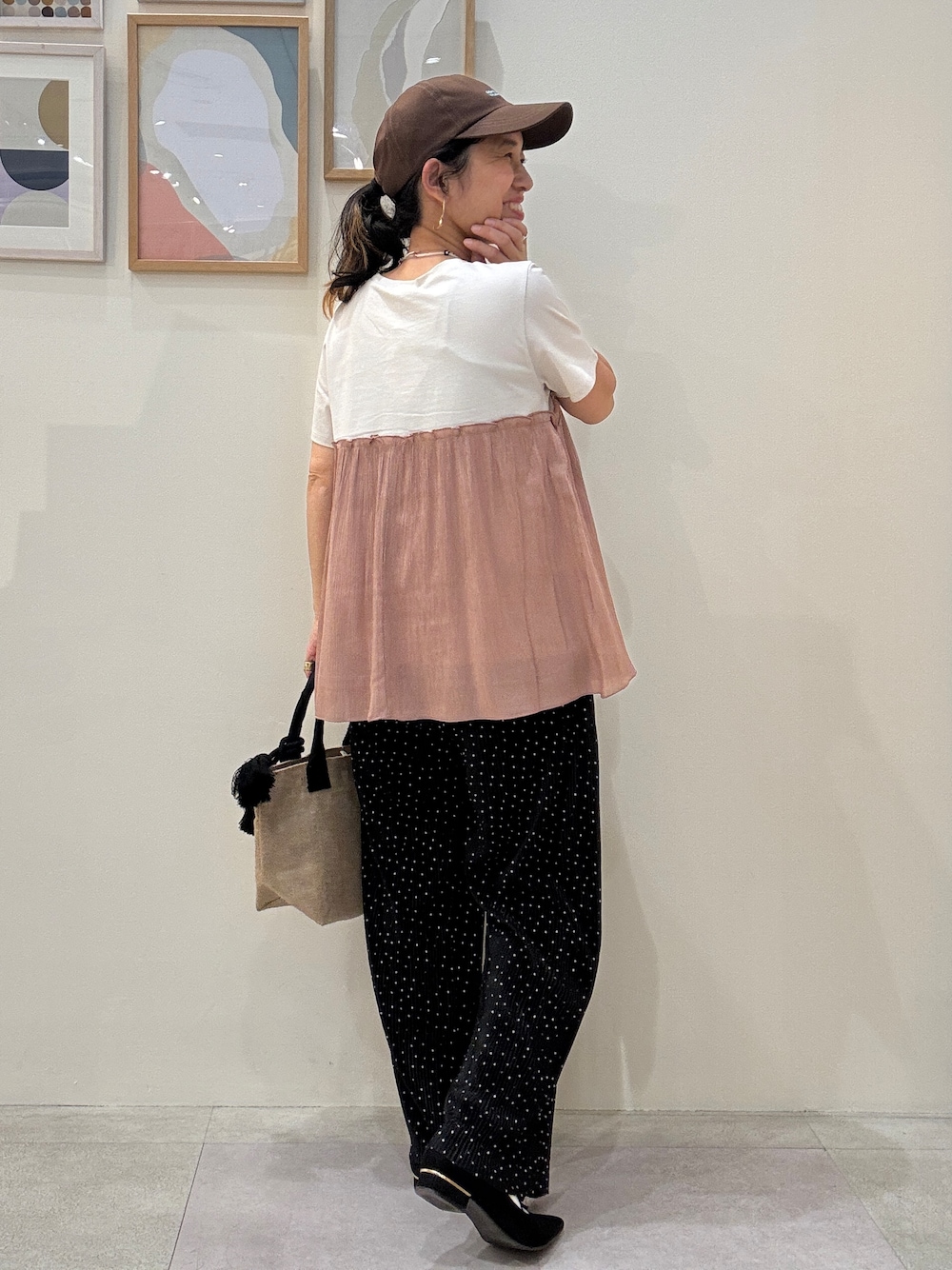 ブラック系のトートバッグ、オレンジ系のTシャツ/カットソー、ブラック系のその他パンツを着用したレディースの春コーディネートの3枚目の写真