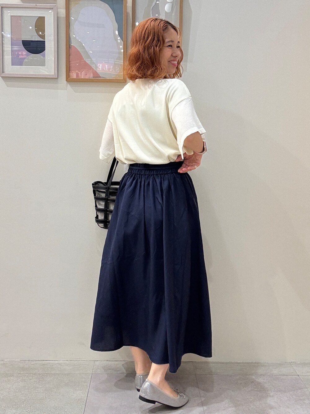 ホワイト系のカーディガン/ボレロ、ホワイト系のニット/セーター、ブルー系のスカートを着用したレディースの夏コーディネートの3枚目の写真