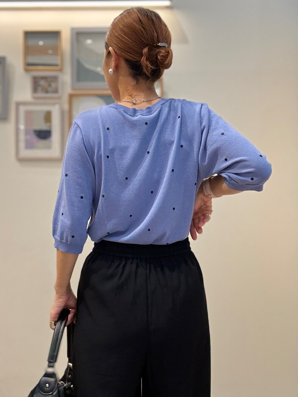 ブルー系のニット/セーター、ブラック系のその他パンツ、ブラック系のショルダーバッグを着用したレディースの夏コーディネートの6枚目の写真