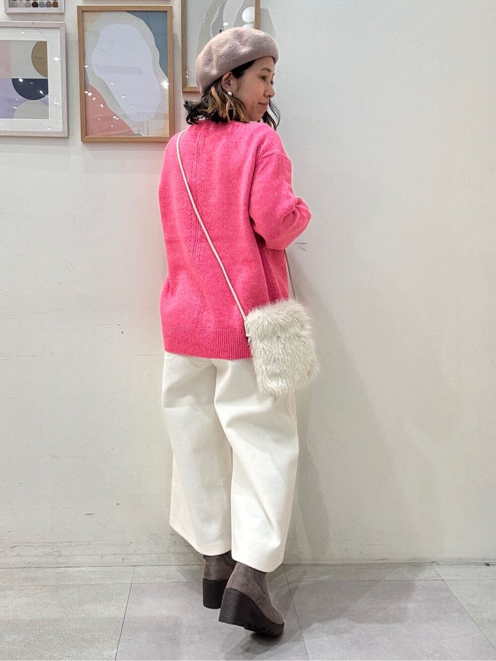ピンク系のニット/セーター、ホワイト系のその他パンツ、ブラウン系のブーツを着用したレディースの冬コーディネートの3枚目の写真