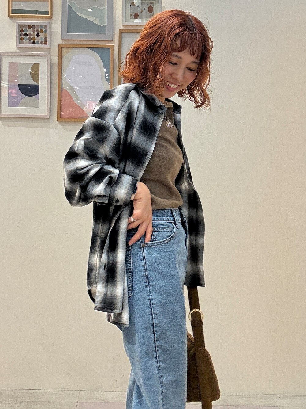 グレー系のシャツ/ブラウス、イエロー系のTシャツ/カットソー、ブルー系のデニムパンツを着用したレディースの秋コーディネートの4枚目の写真
